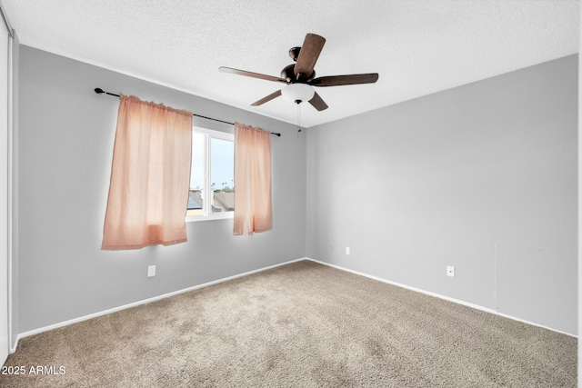 carpeted spare room with ceiling fan, baseboards, and a textured ceiling