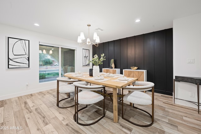 dining area featuring an inviting chandelier and light hardwood / wood-style floors