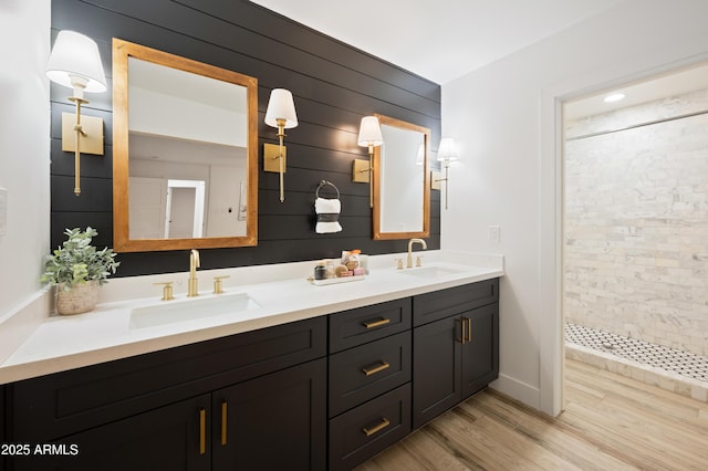 bathroom with vanity, wood-type flooring, and a tile shower