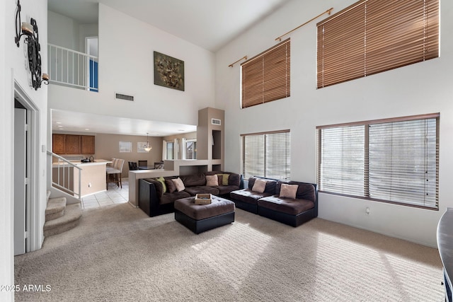 carpeted living room featuring a high ceiling