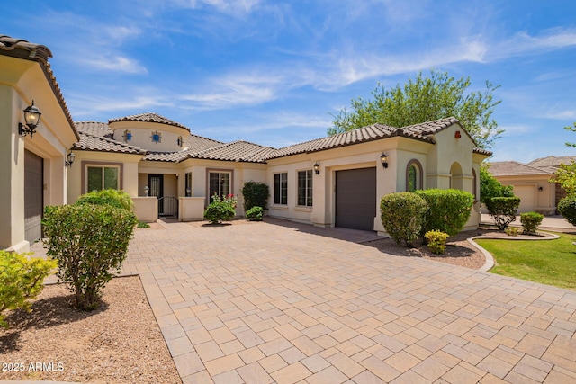 2457 E Melrose St, Mesa, AZ 85213 - mediterranean / spanish house featuring a garage, decorative driveway, stucco siding, and a tile roof