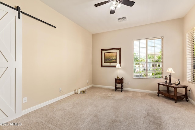 2457 E Melrose St, Mesa, AZ 85213 - empty room featuring light colored carpet, a barn door, a ceiling fan, and baseboards
