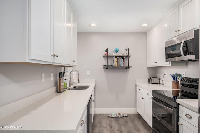 6480 N 82nd St Unit 1136, Scottsdale, AZ 85250 - kitchen with stainless steel appliances, a sink, wood finished floors, white cabinets, and baseboards