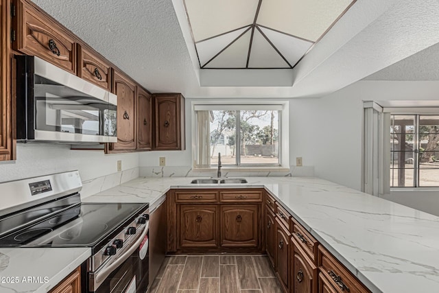 6701 W Monterey Way, Phoenix, AZ 85033 - kitchen with appliances with stainless steel finishes, a sink, light stone countertops, wood finish floors, and a textured ceiling