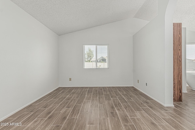 6701 W Monterey Way, Phoenix, AZ 85033 - spare room with a textured ceiling, wood finished floors, lofted ceiling, and baseboards