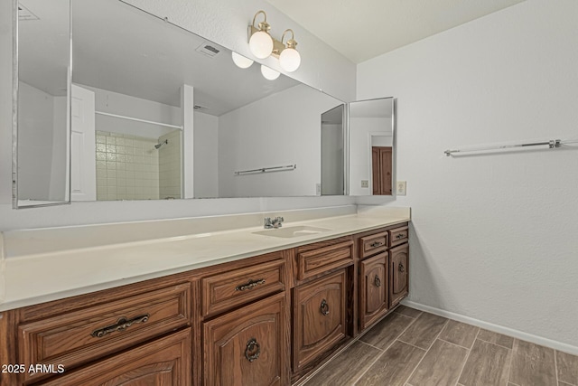 6701 W Monterey Way, Phoenix, AZ 85033 - full bath with vanity, baseboards, wood finished floors, and tiled shower