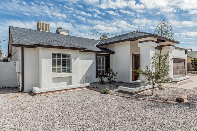 6701 W Monterey Way, Phoenix, AZ 85033 - rear view of house featuring a garage, roof with shingles, stucco siding, and a chimney