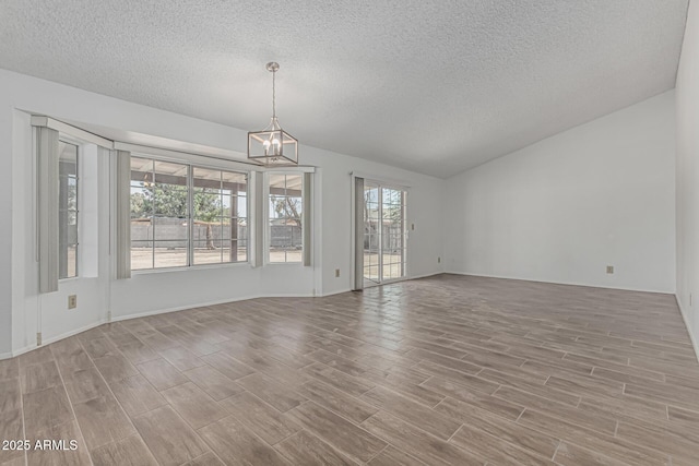 6701 W Monterey Way, Phoenix, AZ 85033 - unfurnished dining area with a textured ceiling, wood finished floors, lofted ceiling, a chandelier, and baseboards
