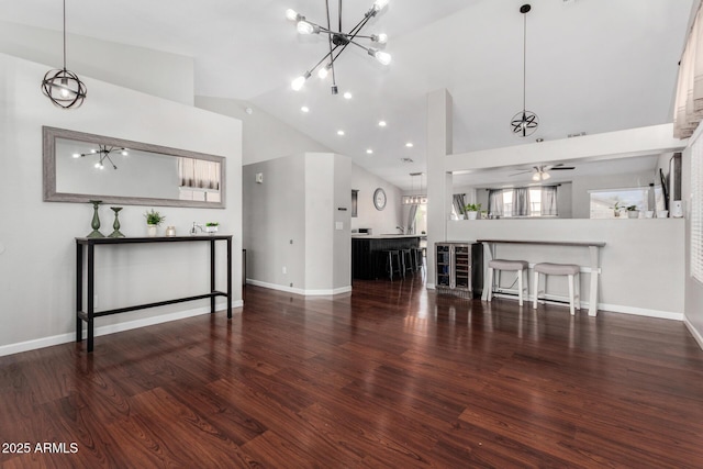 unfurnished living room with ceiling fan, baseboards, wine cooler, and wood finished floors