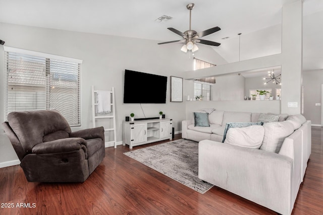 living area with visible vents, plenty of natural light, wood finished floors, and vaulted ceiling