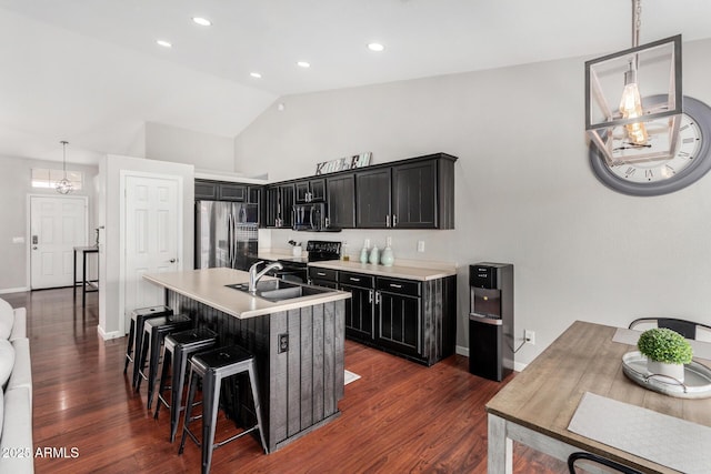 kitchen with dark wood-type flooring, light countertops, dark cabinetry, stainless steel appliances, and a sink