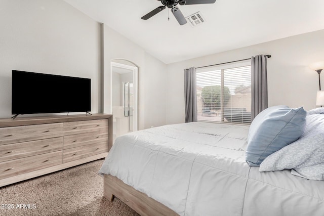 bedroom with visible vents, a ceiling fan, connected bathroom, carpet floors, and lofted ceiling