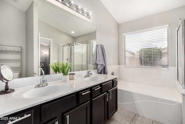 full bath featuring tile patterned floors, a bath, a stall shower, and a sink