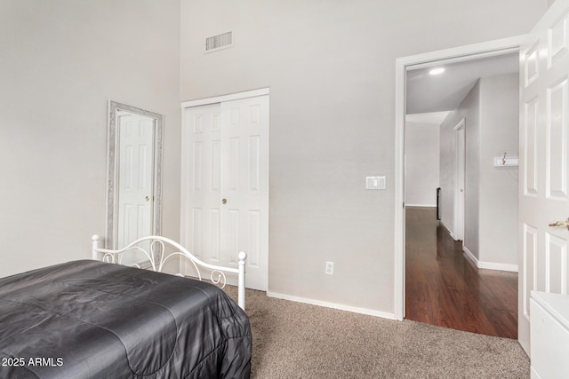 carpeted bedroom featuring visible vents, baseboards, and a closet