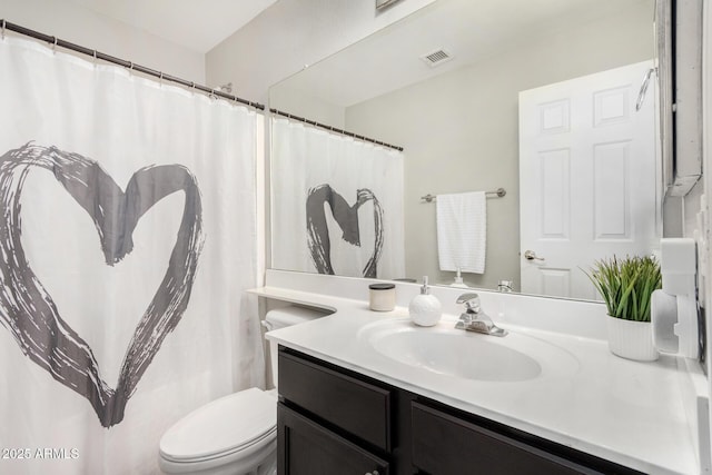 bathroom with vanity, toilet, and visible vents