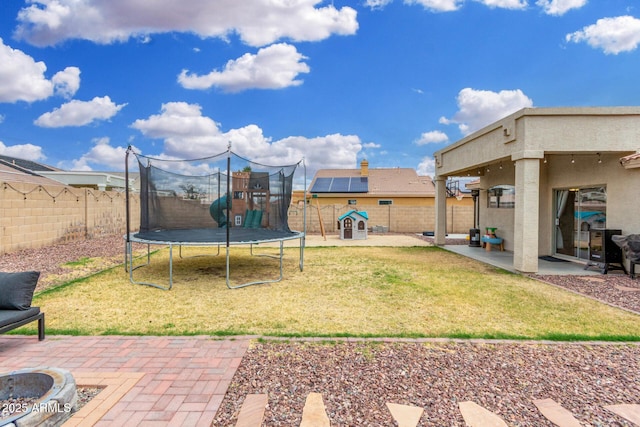 view of yard featuring a playground, a trampoline, a fenced backyard, and a patio area