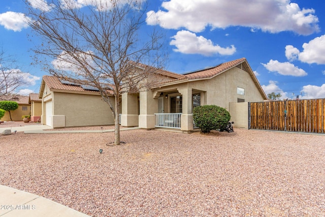 exterior space with a gate, a porch, stucco siding, a garage, and a tiled roof