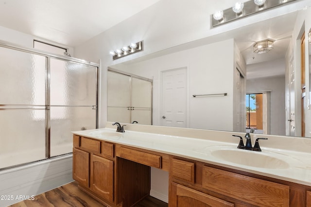 19400 N Westbrook Pkwy Unit 220, Peoria, AZ 85382 - bathroom featuring double vanity, bath / shower combo with glass door, and wood finished floors