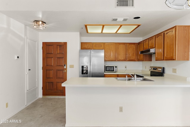 19400 N Westbrook Pkwy Unit 220, Peoria, AZ 85382 - kitchen featuring stainless steel appliances, under cabinet range hood, a peninsula, light countertops, and brown cabinetry