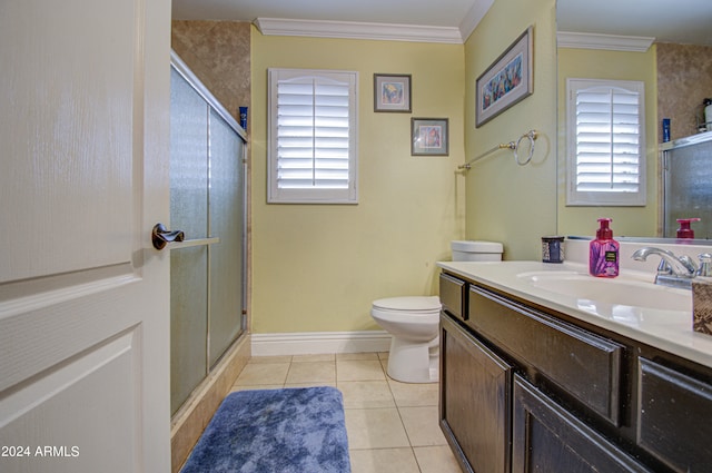 bathroom with tile patterned floors, toilet, a shower with shower door, crown molding, and vanity