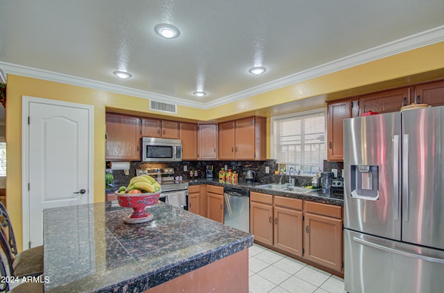 kitchen featuring backsplash, appliances with stainless steel finishes, light tile patterned floors, crown molding, and sink