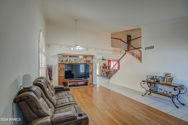 living room with light hardwood / wood-style flooring, crown molding, and ceiling fan