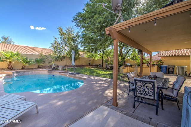 view of pool with a patio area and central AC unit