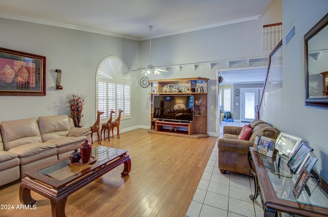 living room with ceiling fan, crown molding, and light wood-type flooring