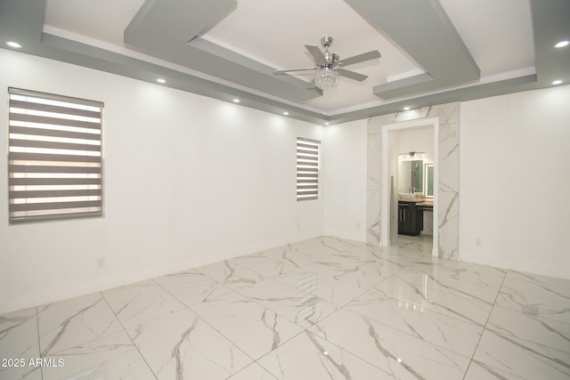 empty room with a tray ceiling and ceiling fan