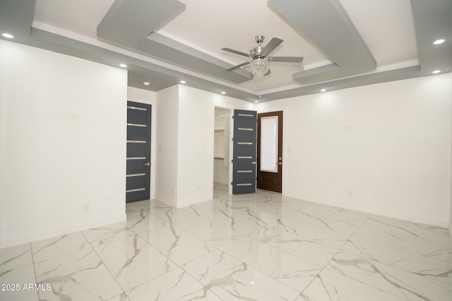 empty room with a tray ceiling and ceiling fan