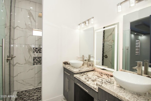 bathroom featuring tiled shower and vanity