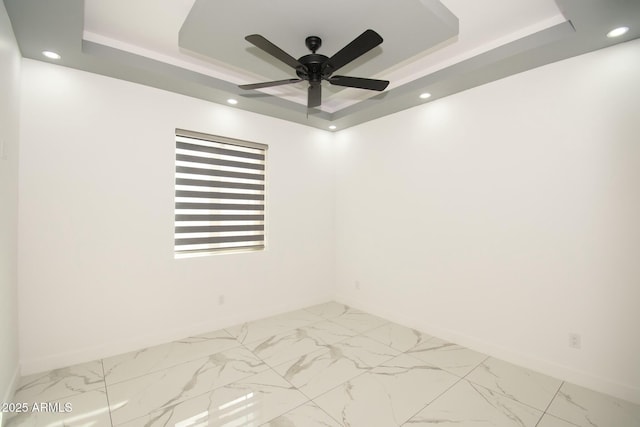 unfurnished room with a raised ceiling and ceiling fan