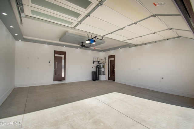 garage with a garage door opener, ceiling fan, and water heater