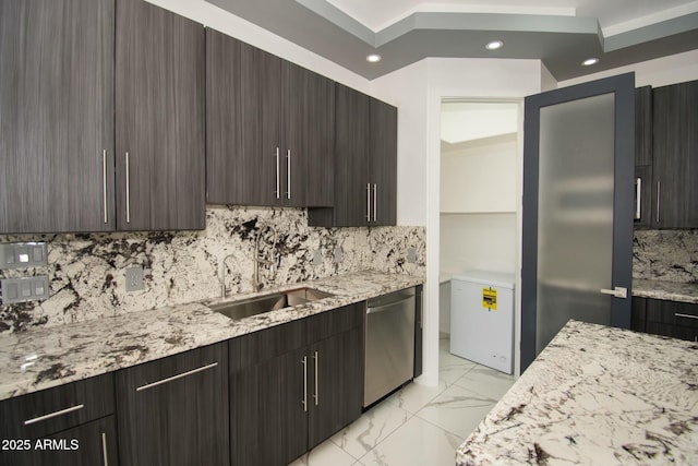 kitchen featuring backsplash, sink, stainless steel dishwasher, light stone countertops, and dark brown cabinetry