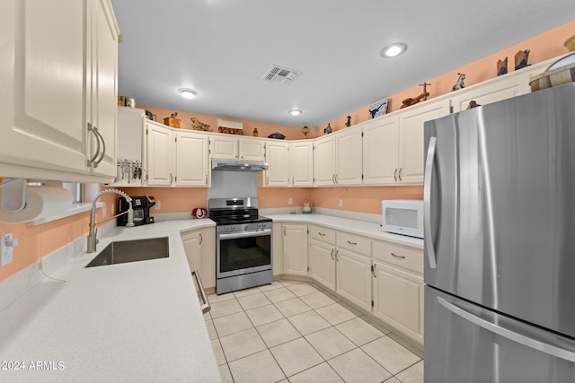 kitchen with appliances with stainless steel finishes, light tile patterned floors, and sink