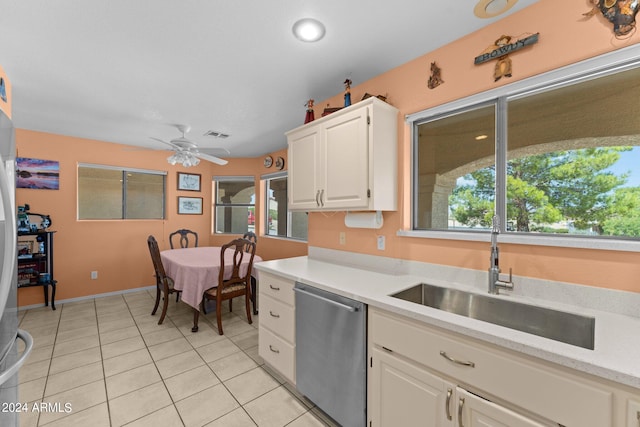 kitchen with light tile patterned floors, dishwasher, sink, ceiling fan, and white cabinets