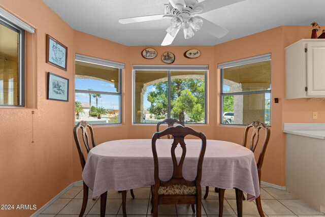 dining space with a healthy amount of sunlight, ceiling fan, and light tile patterned flooring