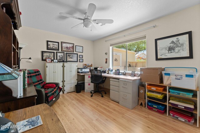 home office with a textured ceiling, light hardwood / wood-style flooring, and ceiling fan