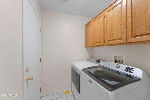 laundry area with cabinets, independent washer and dryer, and light tile patterned flooring