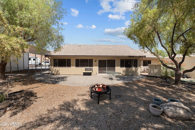 rear view of house featuring a fire pit and a patio