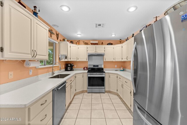 kitchen featuring light tile patterned floors, stainless steel appliances, and sink