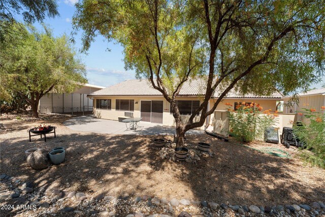 back of house featuring an outdoor fire pit and a patio