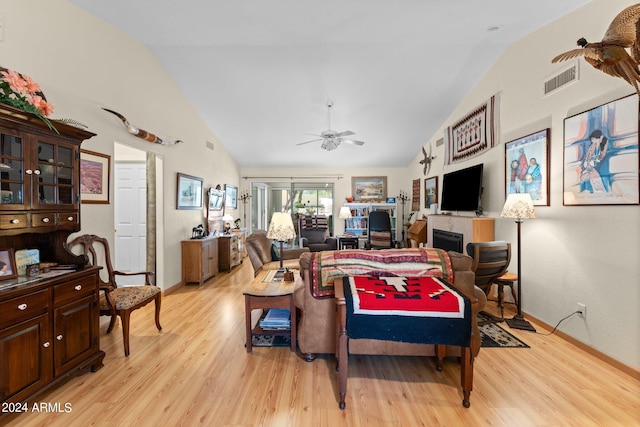 living room with lofted ceiling, ceiling fan, and light hardwood / wood-style floors