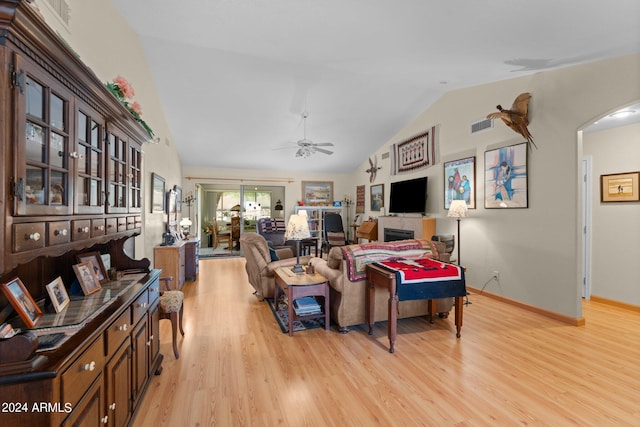 living room featuring ceiling fan, light wood-type flooring, and vaulted ceiling