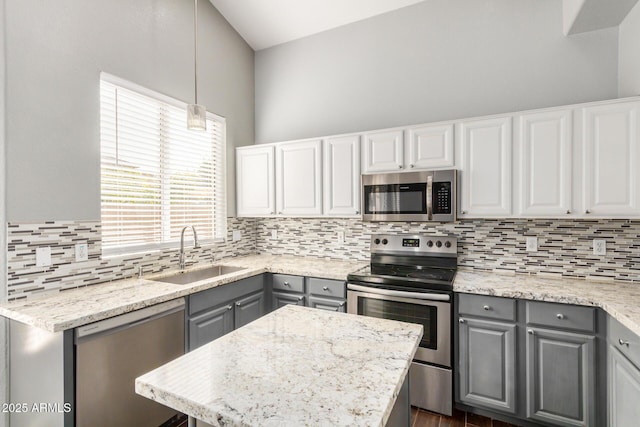 kitchen featuring backsplash, gray cabinets, appliances with stainless steel finishes, and a sink