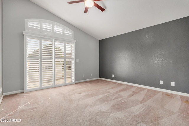 carpeted empty room featuring baseboards, lofted ceiling, and a ceiling fan