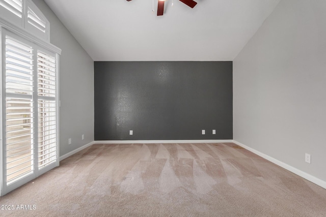 interior space featuring lofted ceiling, baseboards, carpet floors, and ceiling fan