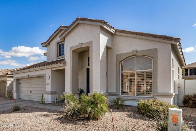 mediterranean / spanish-style home featuring stucco siding, driveway, and a tile roof