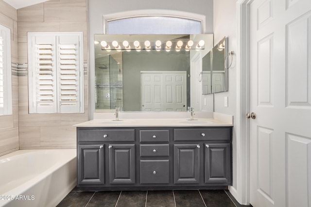 full bathroom with a garden tub, double vanity, a tile shower, tile patterned floors, and a sink