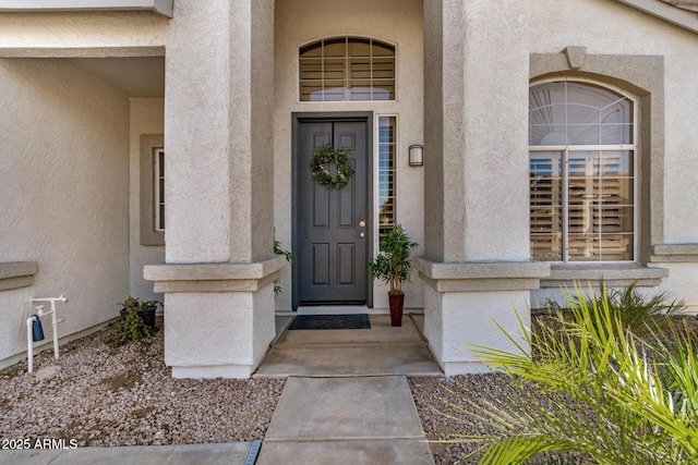 entrance to property featuring stucco siding